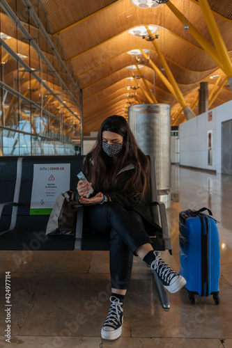 Young woman using hydro alcoholic gel at the airport © Imanol