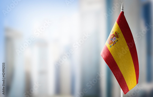 A small flag of Spain on the background of a blurred background