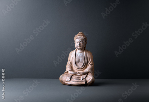 Meditating Buddha Statue on paper background. Copy space. 