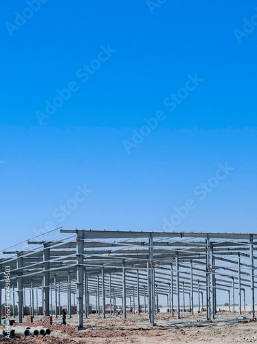 Large steel structure frame of a warehouse under construction. Factory and warehouse structure. © Hor