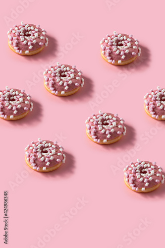Pink marshmallow donut pattern. Many Donuts on pink vertical background.