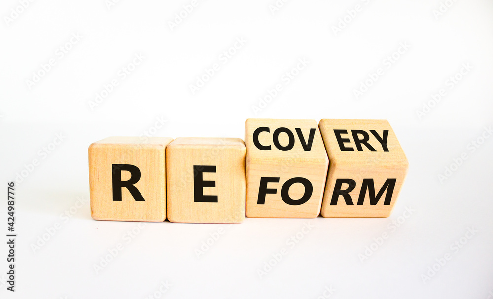 Recovery and reform symbol. Turned cubes and changed the word 'recovery' to 'reform'. Beautiful white background. Business and recovery - reform concept. Copy space. Recovery and reform symbol. Turned cubes and changed the word 'recovery' to 'reform'. Beautiful white background. Business and recovery - reform concept. Copy space.