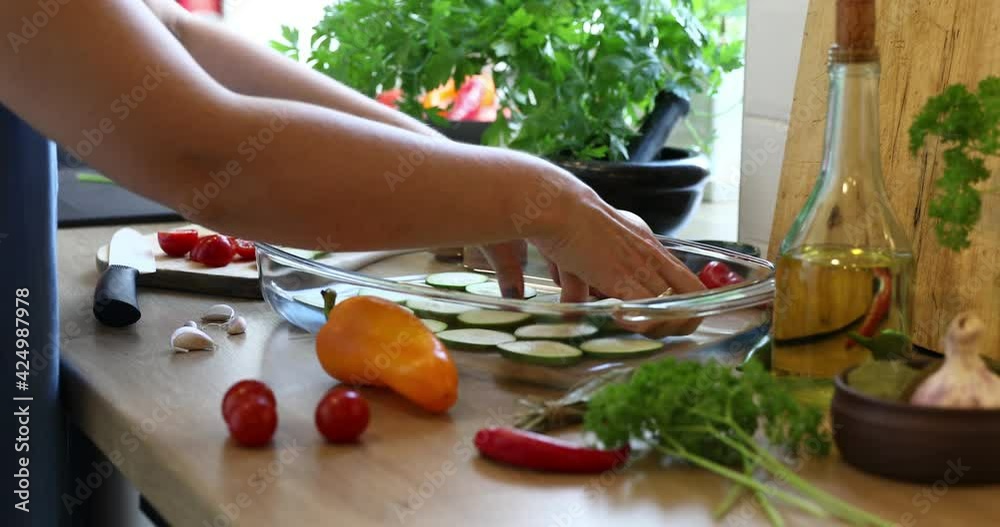 Woman slicing vegetables for cooking on kitchen table. Closeup hands. Close up fresh vegetables on kitchen table. Housewife cooking natural and healthy meal on wooden board.