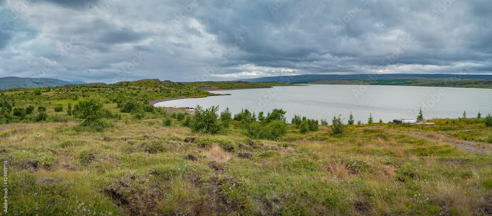 Panoramic view over huge Lagarfjot lake in Iceland at sunny day and dramatic cloudy sky, summer.