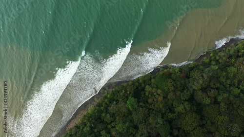 Beautiful series of waves breaking along a coast with tropical jungle aerial top shot Costa Rica photo