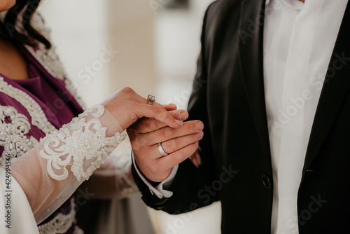 bride and groom holding hands rings