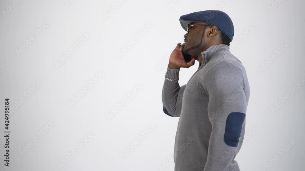 Smiling sportsman talking the phone in studio. Young afro american man with muscular body having a conversation and smiling. Profile view. Copy space. Smiling sportsman talking the phone in studio. Young afro american man with muscular body having a conversation and smiling. Profile view. Copy space.