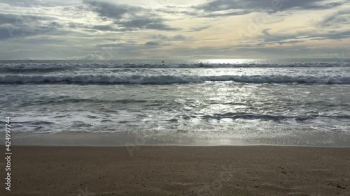 Beautiful big waves at dusk on the beach of Bali, Indonesia, the waves blowing the beach sand, the boisterous waves that keep on rising and the sky is so enchanting.