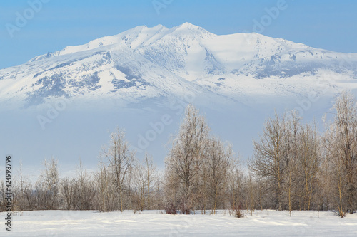 Beautiful mountain landscape. View of trees and snow-capped mountain peaks. Travel and hikes in the wilderness in the Far North of Russia. Remote, hard-to-reach area. Rarytkin Range, Chukotka, Siberia © Andrei Stepanov