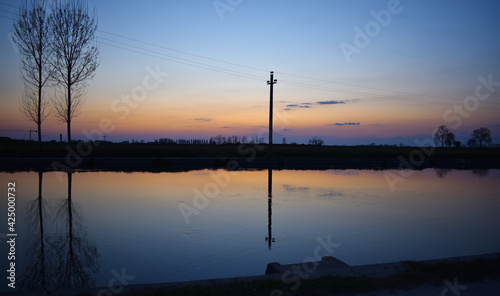 incredible sunset on the Muzza river, lights, colors and reflections surround this breathtaking landscape photo