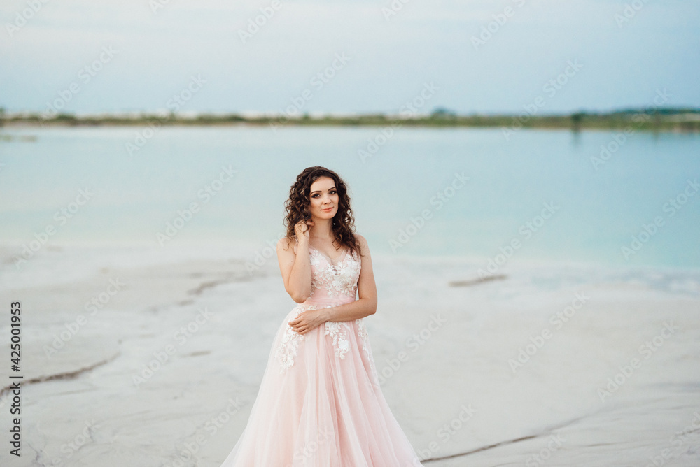girl in a pink dress are walking along the white sand