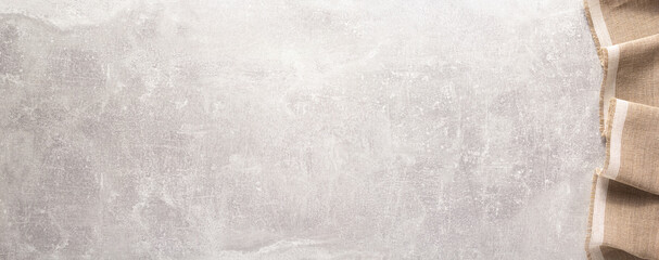 Folded tablecloth at stone or marble surface of table. Top view as panorama of cloth napkin texture background