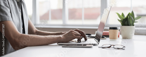 Man typing on computer keyboard panoramic banner, businessman, designer or student using laptop at home, online learning, internet marketing, working from home, office workplace concept photo