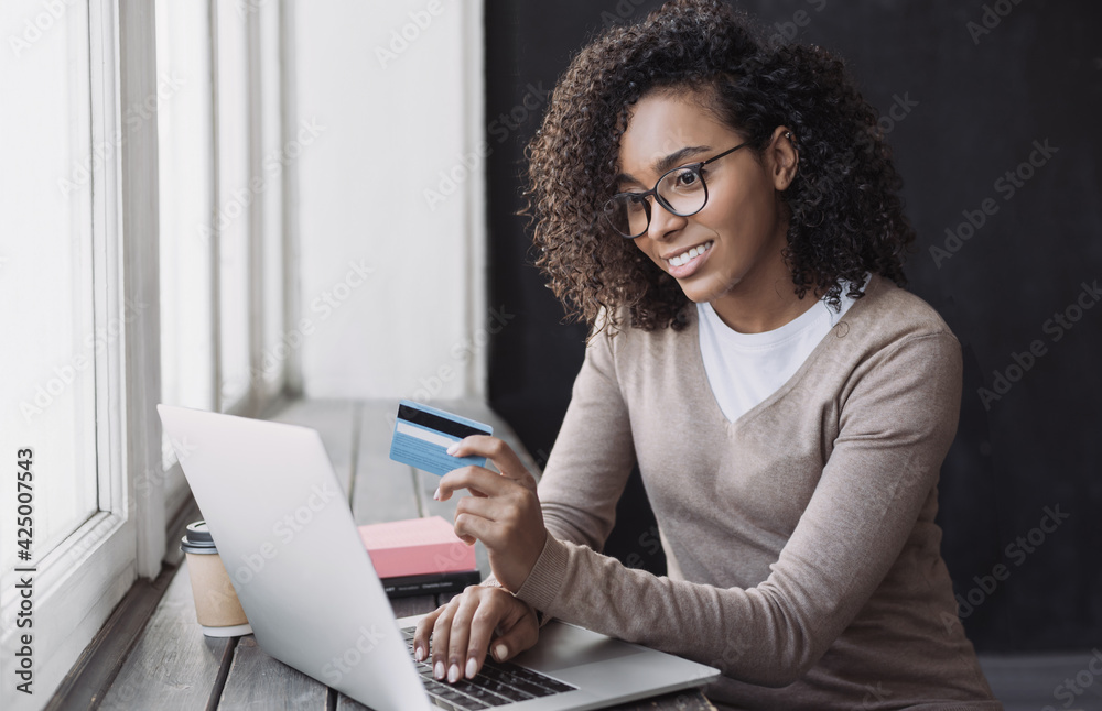 Young woman holding credit card and using laptop making payment online, Businesswoman or entrepreneur working at home, Online shopping, e-commerce, banking, internet store, spending money concept Young woman holding credit card and using laptop making payment online, Businesswoman or entrepreneur working at home, Online shopping, e-commerce, banking, internet store, spending money concept