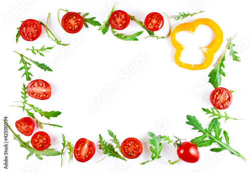 Frame made of halved tomatoes with rucola leaves and slice of yellow sweet pepper isolated on a white background. Top view.