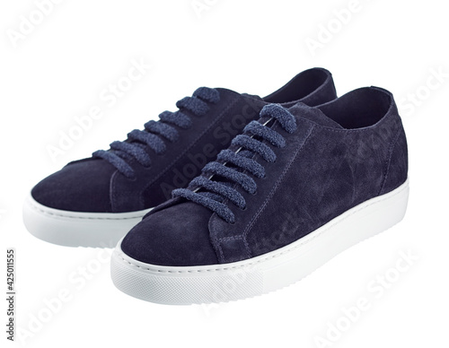 Beautiful pair of elegant shoes made of dark blue suede with laces and white soles isolated on a white background. Trends of the season: comfortable shoes made of natural materials.