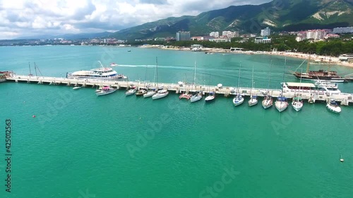 Aerial photography of seaport in the resort of Gelendzhik, yachts and sailboats on Black Sea coast beaches and part of city panorama photo