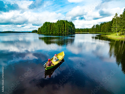Quadro su tela Aerial view of fishing boat with couple in blue summer lake in Finland