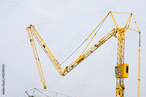 Arm of yellow tower crane fold up at construction site