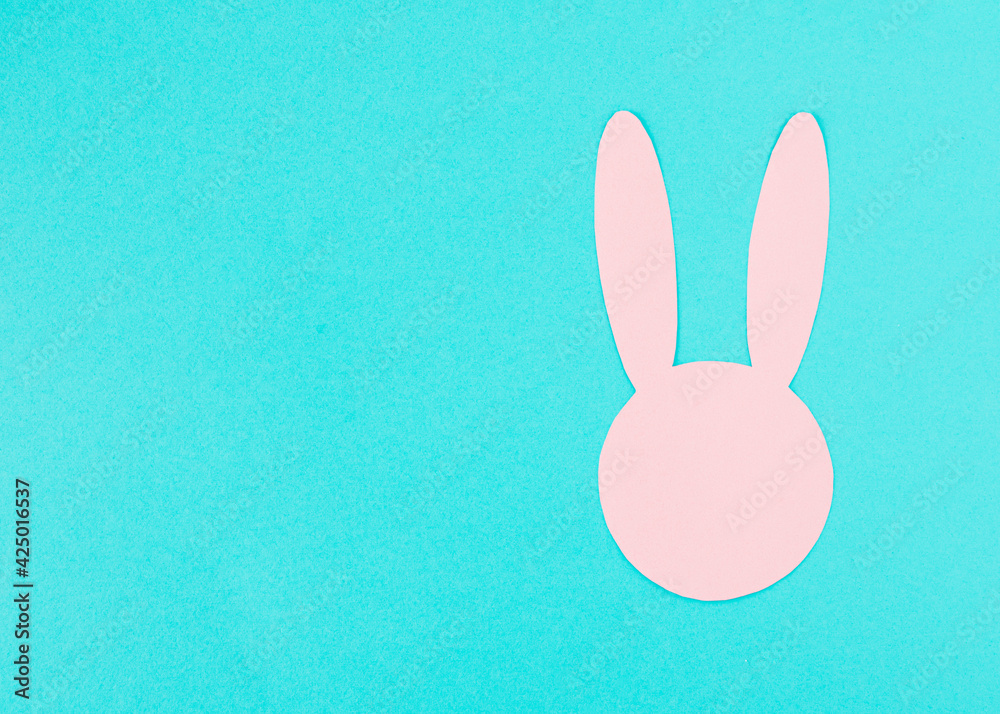 Pink paper rabbit head on a bright background. Minimal Easter concept with place for a message Pink paper rabbit head on a bright background. Minimal Easter concept with place for a message