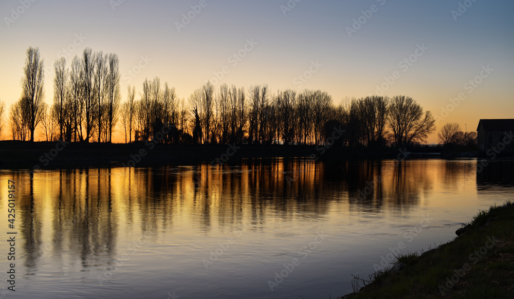 beautiful sunset on the river, colors, lights and reflections surround this wonderful countryside landscape