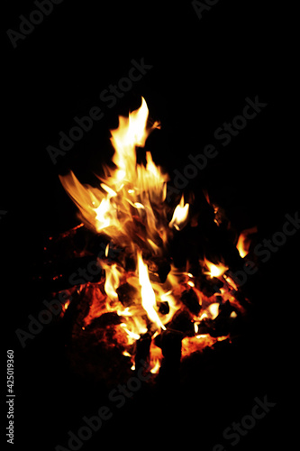 Bonfire winter dark night, view from top. Flame sores rise into lens. Roast oneself at fire on black backgroung isolated photo