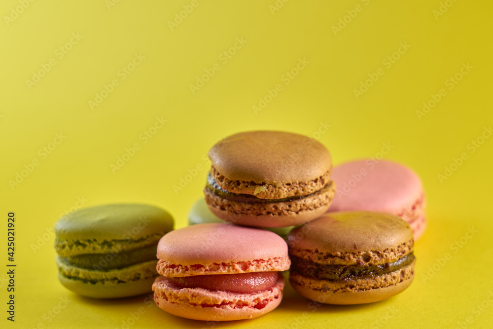 Cake macaron close up on yellow background flavor almond cookies pastel colors. Cake macaron close up on yellow background flavor almond cookies pastel colors.