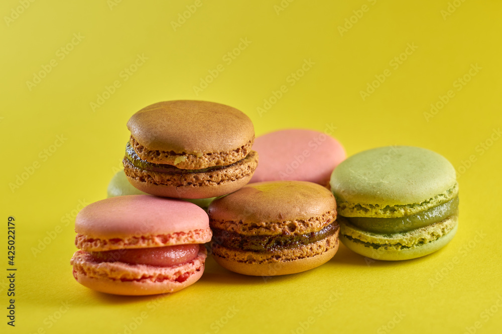 Cake macaron close up on yellow background flavor almond cookies pastel colors. Cake macaron close up on yellow background flavor almond cookies pastel colors.