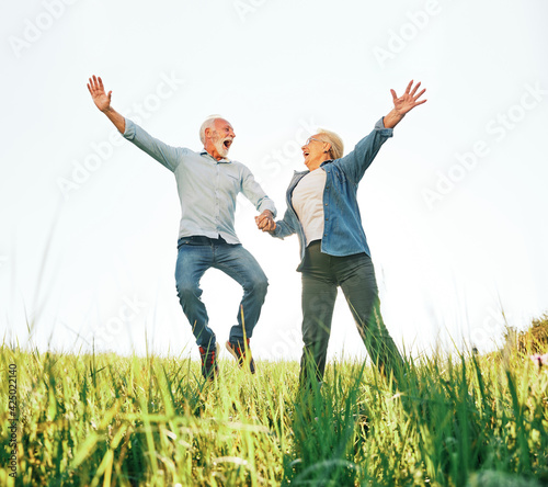 woman man outdoor senior couple happy lifestyle retirement together love jumping fun nature mature photo