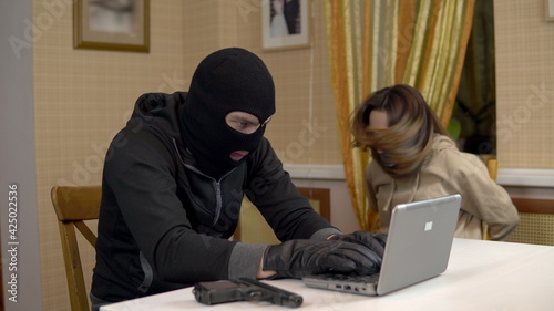 Photos A burglar is trying to break into a laptop by taking a young woman hostage