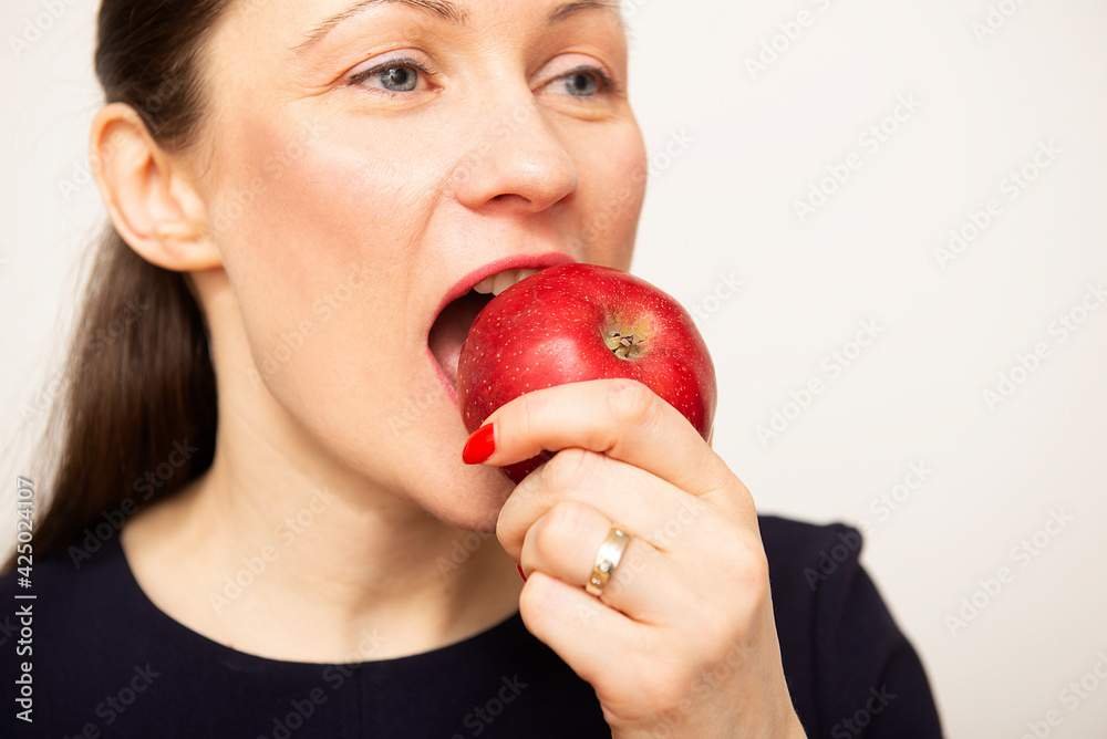 Close-up of beautiful young woman face eating an apple . White isolated background Close-up of beautiful young woman face eating an apple . White isolated background