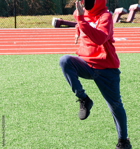 Runner practicing dports drills on turf field at track practice photo