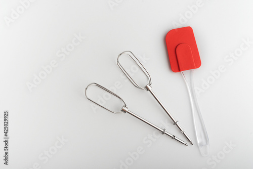 Kitchen tools mixer whiskas and kitchen silicone spatula on white background.