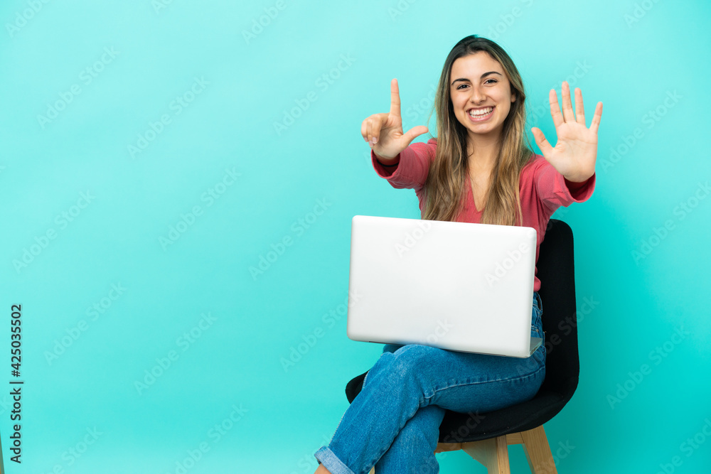 Young caucasian woman sitting on a chair with her pc isolated on blue background counting seven with fingers Young caucasian woman sitting on a chair with her pc isolated on blue background counting seven with fingers