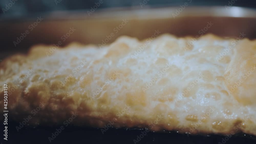 The process of frying chebureks. Sizzling oil The process of frying chebureks. Sizzling oil