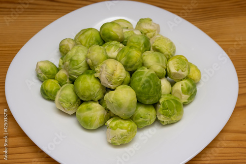 Serving Brussels sprouts on a white plate for cooking. Diet vegan food.