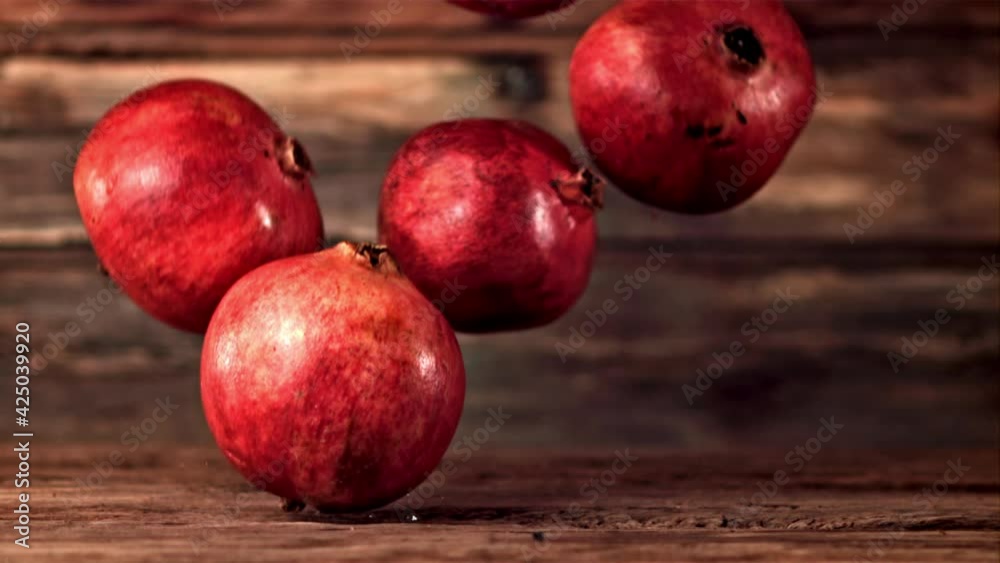 Super slow motion pomegranates fall on a wooden table. On a wooden background.Filmed on a high-speed camera at 1000 fps. High quality FullHD footage Super slow motion pomegranates fall on a wooden table. On a wooden background.Filmed on a high-speed camera at 1000 fps. High quality FullHD footage