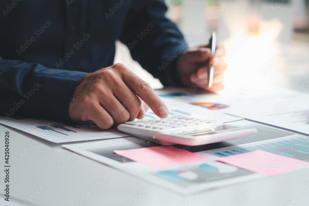 businessman working on desk office with using a calculator to calculate the numbers, finance accounting concept businessman working on desk office with using a calculator to calculate the numbers, finance accounting concept