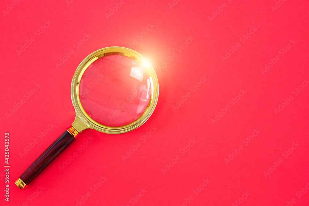 Magnifying glass on a bright red background. Magnifying glass on a bright red background.