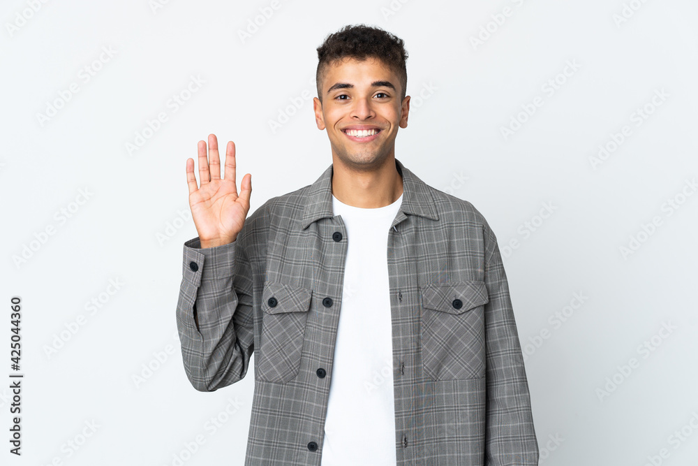 Young brazilian man isolated on white background saluting with hand with happy expression Young brazilian man isolated on white background saluting with hand with happy expression