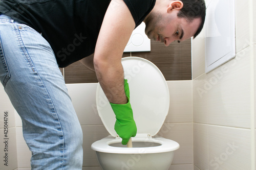 Drain Problems, blockage plumbing toilet unclog plunger force cup man sit floor