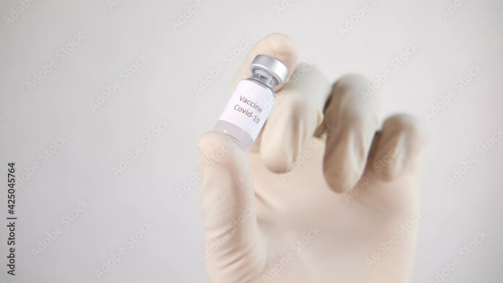 hand in latex gloves holding glass ampoule vaccine on white background hand in latex gloves holding glass ampoule vaccine on white background