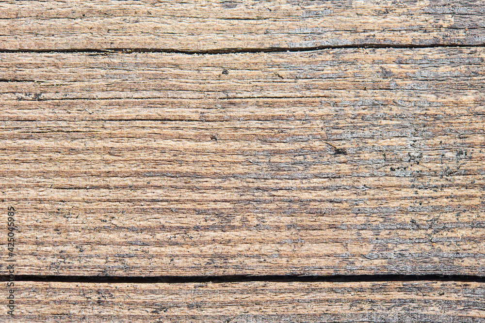Old sandy weathered washed tainted wood texture with horizontal cracks and grains of river sand. Natural textured closeup dry plank background. Old sandy weathered washed tainted wood texture with horizontal cracks and grains of river sand. Natural textured closeup dry plank background.