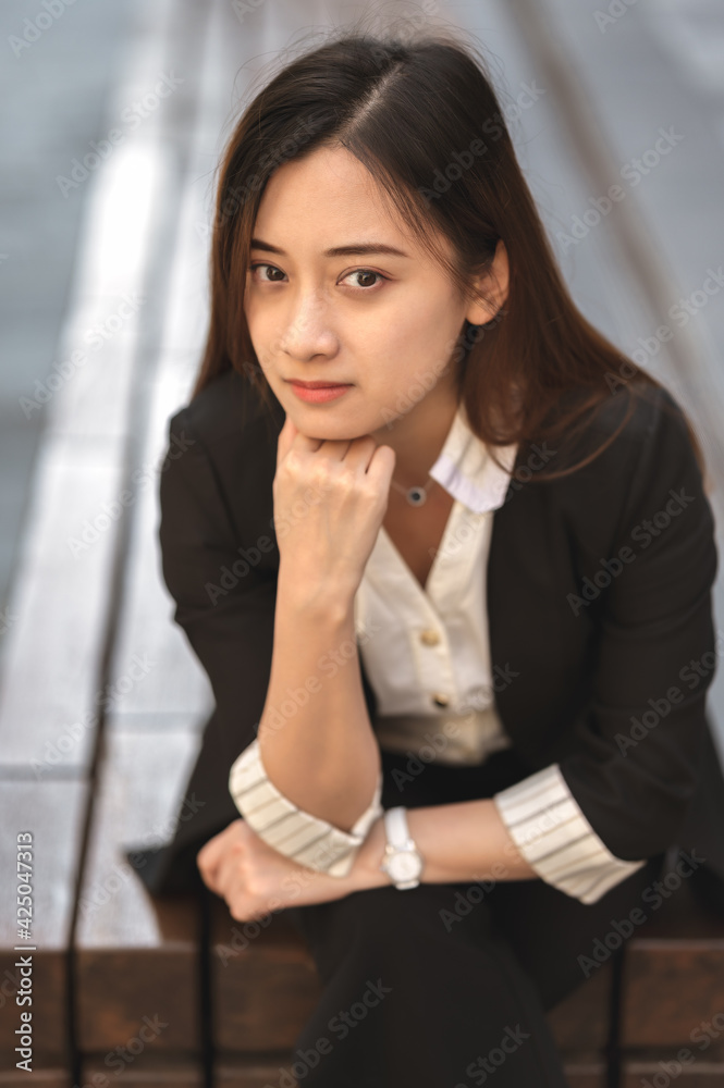 A young asian woman in black suit.