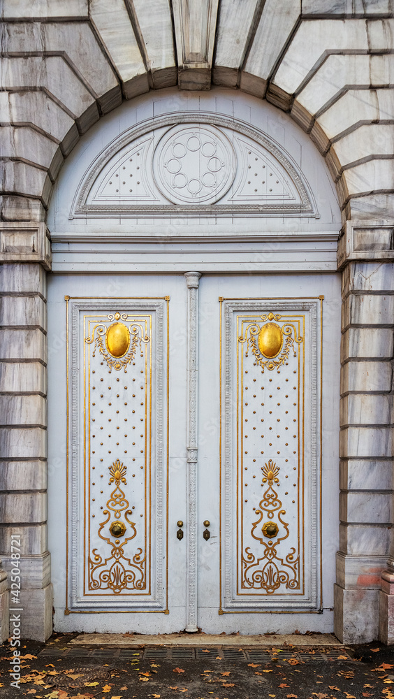 Historic white gate decorated with gold pattern. View from Dolmabahce street in Besiktas district of Istanbul, Turkey