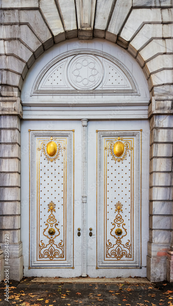 Historic white gate decorated with gold pattern. View from Dolmabahce street in Besiktas district of Istanbul, Turkey Historic white gate decorated with gold pattern. View from Dolmabahce street in Besiktas district of Istanbul, Turkey