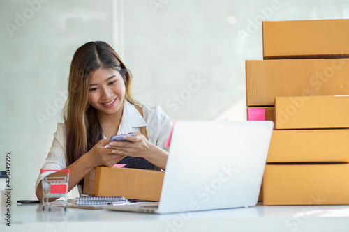 Portrait of Starting small businesses SME owners female entrepreneurs working, box and check online orders to prepare to pack the boxes, sell to customers, sme business ideas online.