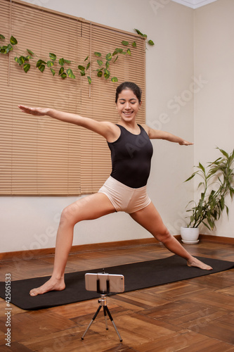 Young woman performs yoga in house photo