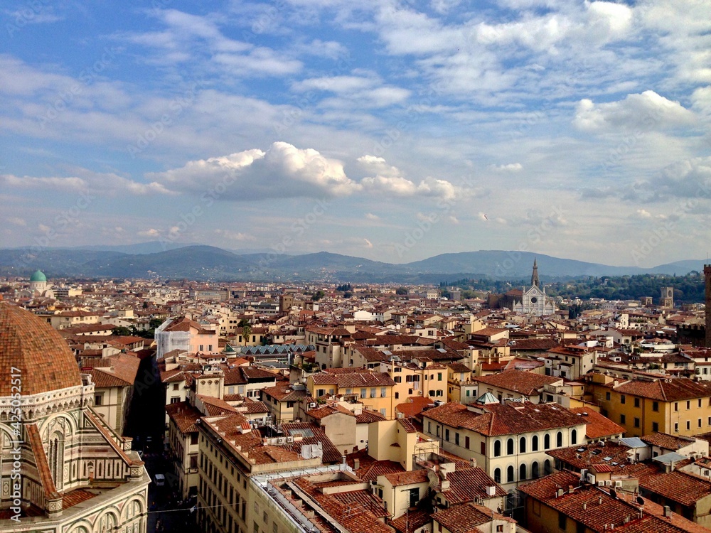 FIRENZE, ITALY. Panoramic view of Florence from the top of Duomo Santa Maria del Fiore. Tuscany hills on a horizon. Golden hour, cloudy sky. 