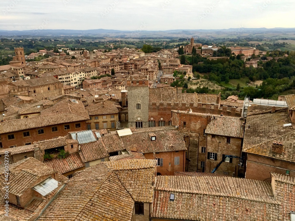 Piazza del Campo view, Siena, Italy. Panorama view of Siena from Cathedral. Evening, cloudy sky, Tuscany hills on a background, tile rooftop, medieval town.